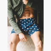 Man lifting shirt to show abs wearing blue slim fit boxers with white dots.