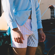 Man standing in pastel stripe slim fit boxers in front of vintage car.